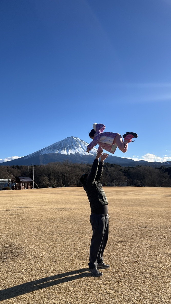 家人在山下公園草地上合照 背景是富士山