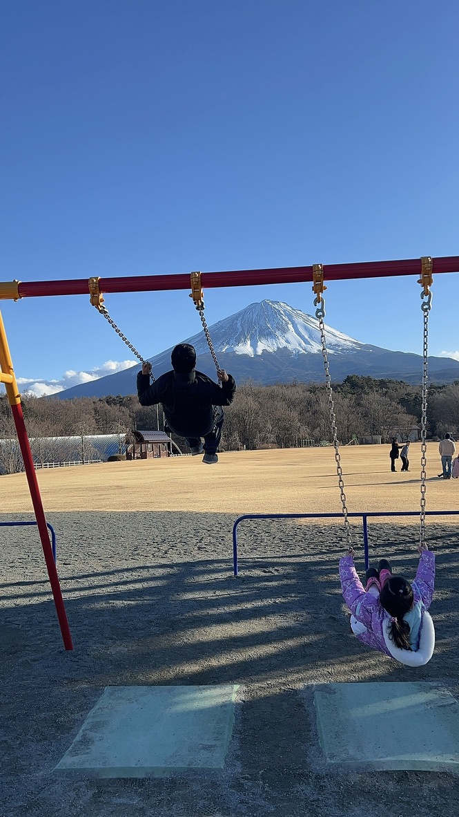 家人在山下公園盪鞦韆 背景是富士山